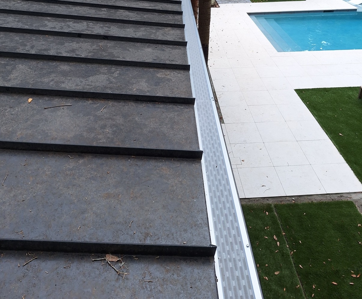 ValueFilter gutter protection installed along a standing-seam roof beside a pool and patio