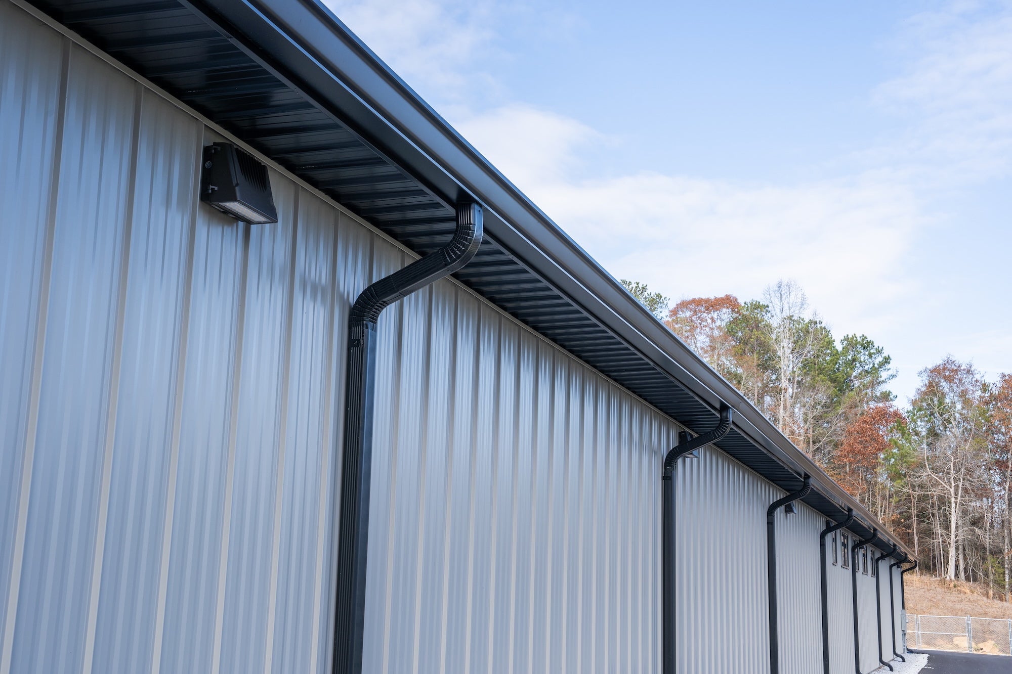Commercial seamless rain gutters installed on a metal building