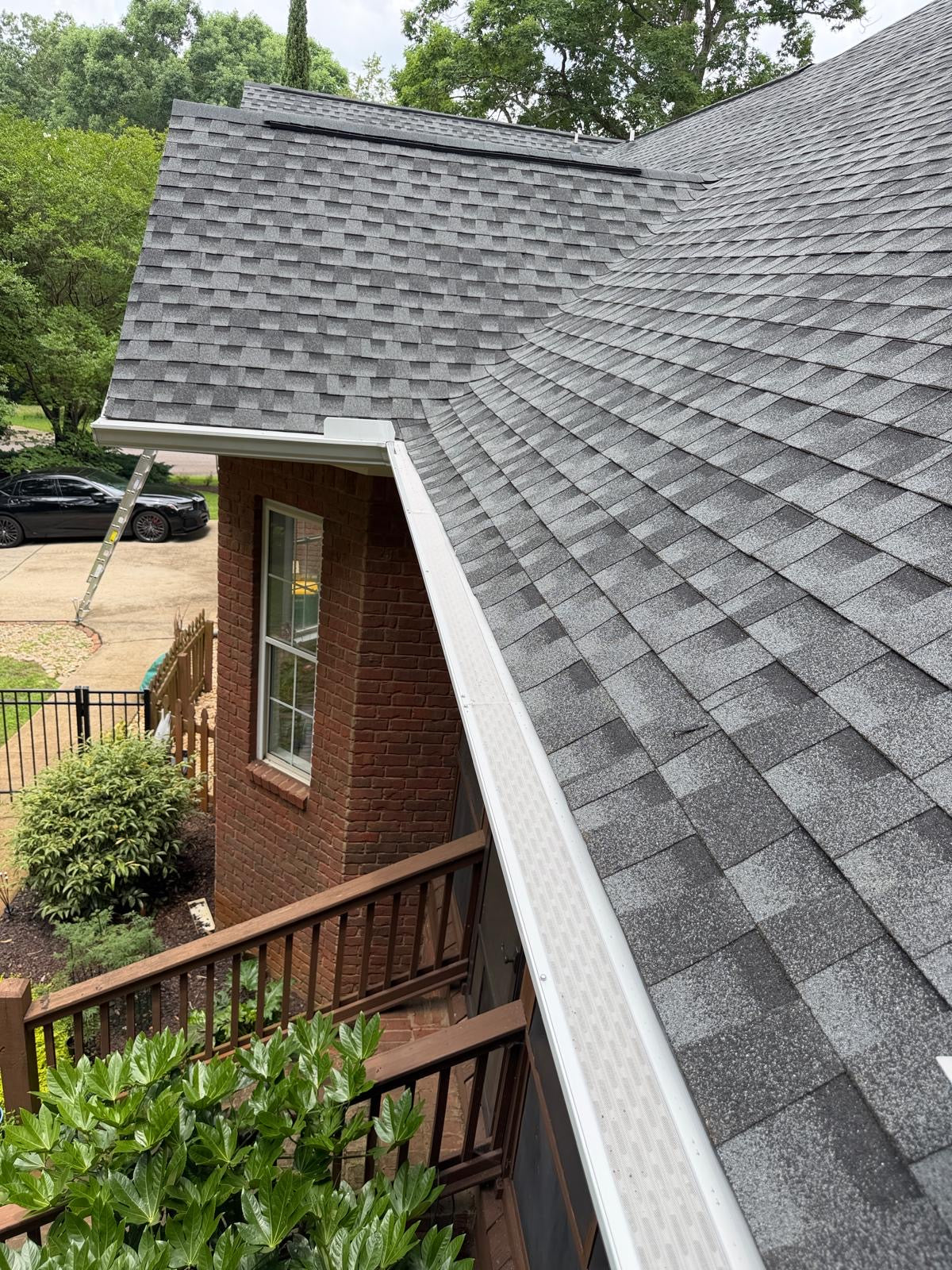 White gutter guard installation above deck and patio area